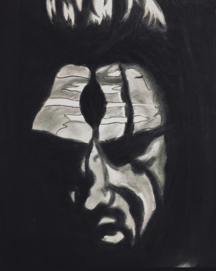 A shadowed face study with a pale forehead marking and dramatic charcoal contrast